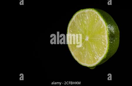 Sliced green lime on the black background. Stock Photo