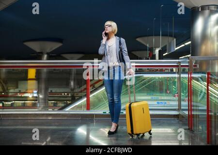 BusinessWoman with luggage talking on phone Stock Photo