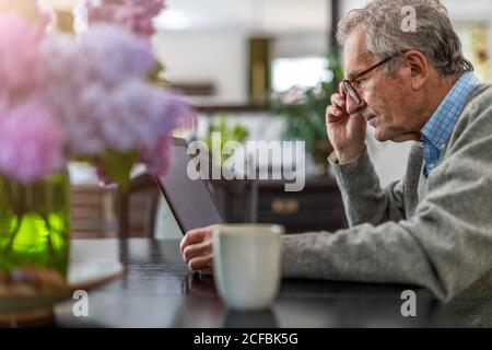 Senior man using laptop at home Stock Photo