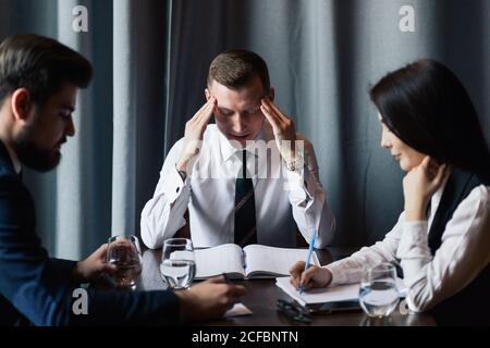 business, teamwork, people and crisis concept - business team sitting sad and solving problem in office Stock Photo
