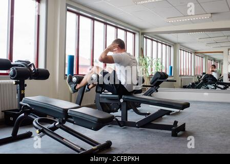 man doing sit ups using equipment working his abs at the gym Stock Photo