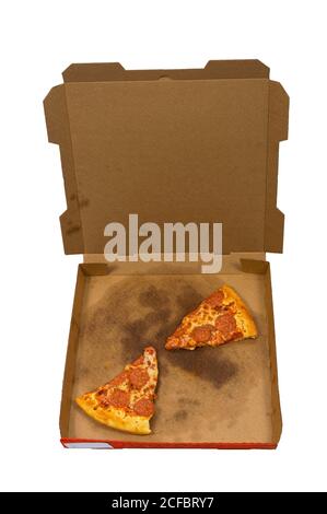 Vertical overhead shot of some slices of leftover pizza in a delivery box isolated on white background. Stock Photo