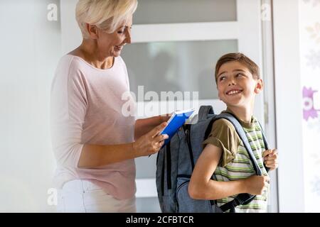 Mother and son with backpack in entrance hall Stock Photo