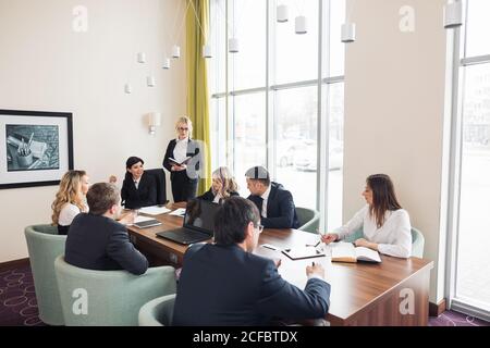 Female Manager Leads Meeting Around Table In Design Office Stock Photo