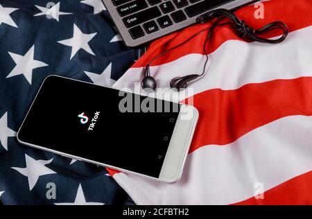 NEW YORK NY September 02 2020: Tik Tok application icon on smartphone screen American flag waving with modern headphones with cellphone Stock Photo