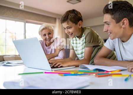 Mother helping her kids doing homework at home Stock Photo