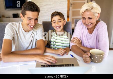 Mother with her two sons using laptop at home Stock Photo