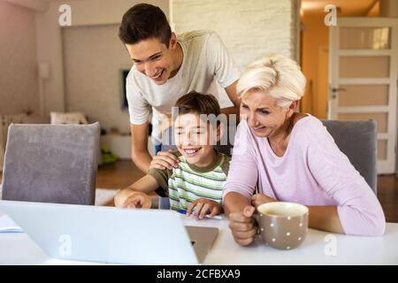 Mother with her two sons using laptop at home Stock Photo