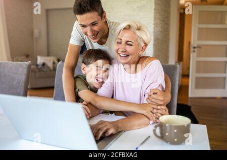 Mother with her two sons using laptop at home Stock Photo