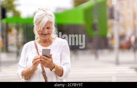 Portrait of senior woman using smartphone in the city Stock Photo