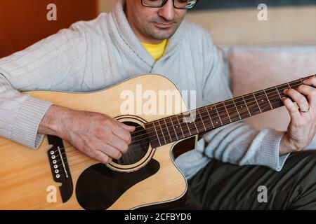 man playing the guitar at home Stock Photo