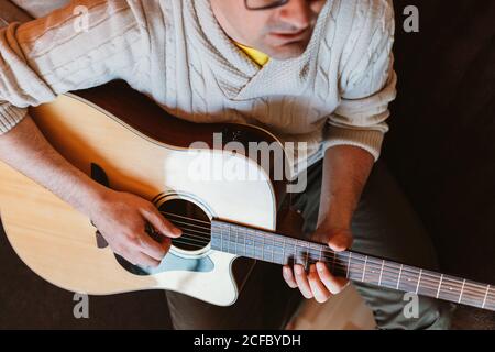 man playing the guitar at home Stock Photo
