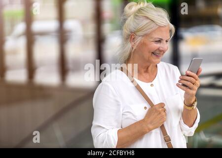 Portrait of senior woman using smartphone in the city Stock Photo