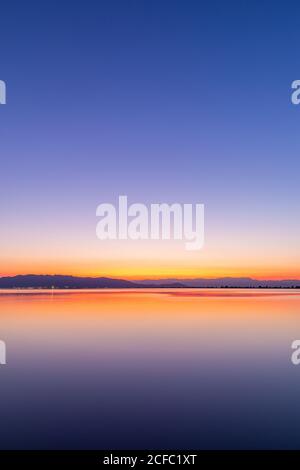 Intense colors of a sunset with reflections in the water Stock Photo