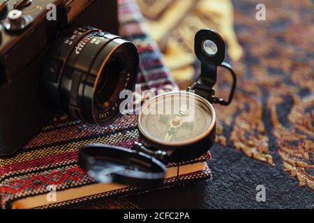 Closeup of arranged vintage photo camera with compass on rustic notepad Stock Photo