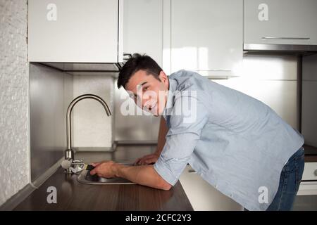 Male Plumber In Overall Fixing Sink Pipe. Stock Photo