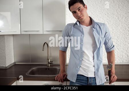 Plumber man with tools in the kitchen. Plumbing and renovation. Stock Photo