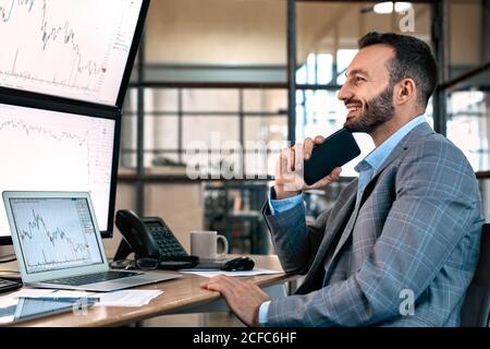 Broker analyzing stat and dynamic on forex charts and smiling wide Stock Photo