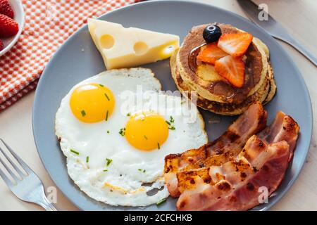 Delicious fried eggs with bacon and cheese for breakfast Stock Photo