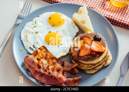 Delicious fried eggs with bacon and cheese for breakfast Stock Photo