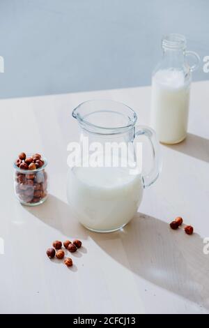 Jar of milk and hazelnuts on table Stock Photo