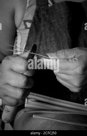 Manos de artesano cosiendo trabajando con fibra vegetal Stock Photo