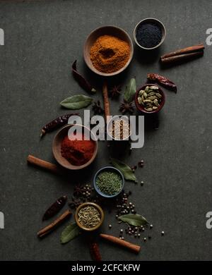 Top view composition with different kinds of natural aromatic spices placed on dark gray background Stock Photo
