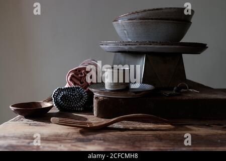 Bakery shapes near dishcloths, paddle, plates and bowls on wooden table on grey background Stock Photo