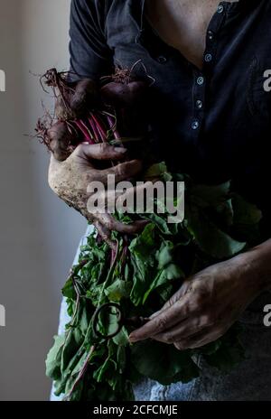 faceless person with bunch of beetroots and key Stock Photo