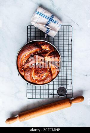 From above fresh strawberry brioche on the making placed near rolling pin and kitchen utensils on white modern marble table Stock Photo