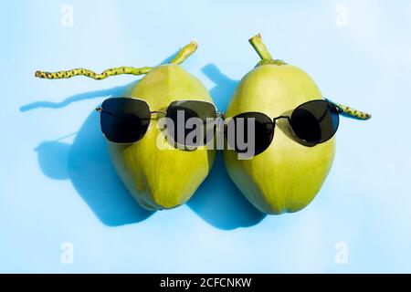 Coconuts with sunglasses on blue background. Stock Photo
