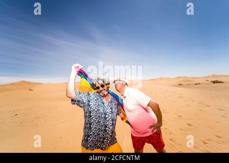 Excited plump gay couple in desert Stock Photo