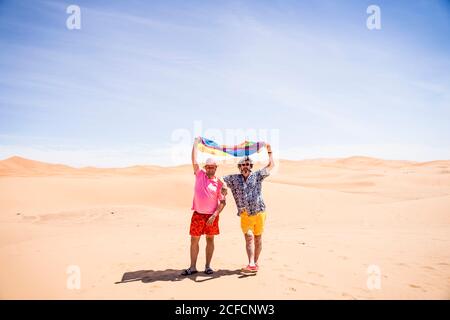 Excited plump gay couple in desert Stock Photo