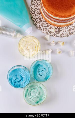Frosting bag with icing and cake on white background. Top view. Stock Photo