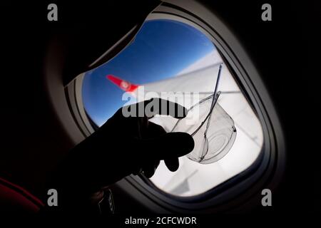 Crop passenger with plastic glass during flight in plane Stock Photo