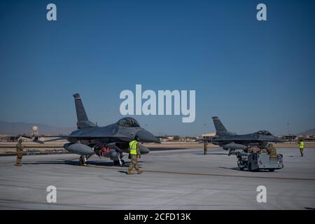 Airmen from the 140th Maintenance Group prepare to load munitions onto F-16 Fighting Falcons from the 120th Fighter Squadron at a simulated austere base during the Advanced Battle Management System exercise on Nellis Air Force Base, Nev., Sept. 3, 2020. The ABMS is an interconnected battle network - the digital architecture or foundation - which collects, processes and shares data relevant to warfighters in order to make better decisions faster in the kill chain. In order to achieve all-domain superiority, it requires that individual military activities not simply be de-conflicted, but rather Stock Photo