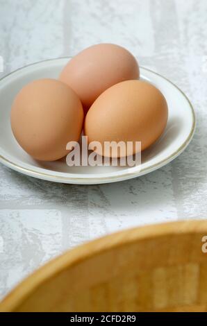Three eggs in a white bowl Stock Photo