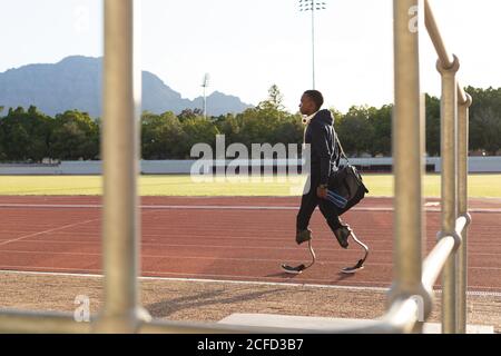 Male athlete with prosthetic legs walking on race track Stock Photo