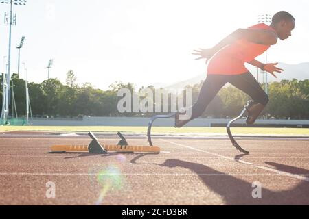 Male athlete with prosthetic legs running on race track Stock Photo