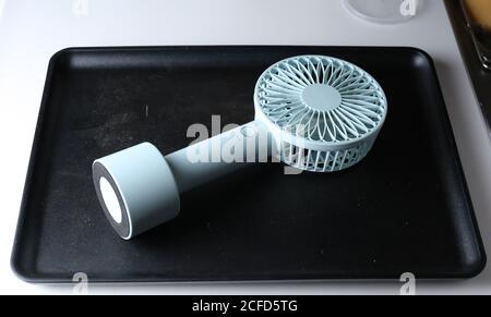 Tokyo, Japan, 09/03/2020 , portable fan with rechargeable batteries on a black tray Stock Photo
