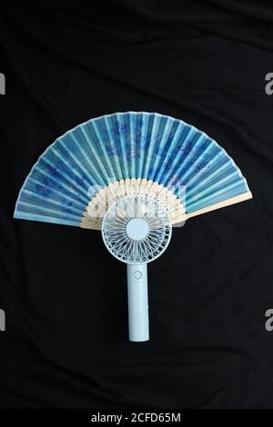 Tokyo, Japan, 09/03/2020 , portable fan with rechargeable batteries together with a traditional japanese hand fan. Stock Photo
