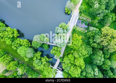 park landscape with pond between green trees in cloudy summer day. aerial drone view Stock Photo