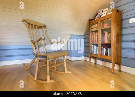 Interior view of living room detail traditional Norwegian wooden house, wooden chair and bookcase, Nordland, Norway Stock Photo