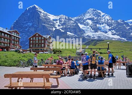 Tourists and hikers on Kleine Scheidegg in front of the Eiger and Moench, Wengen, Jungfrau region, Bernese Alps, Bernese Oberland, Canton of Bern Stock Photo