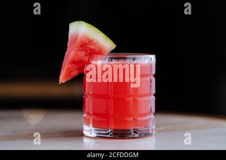 Chilly healthy watermelon smoothie in glass cup decorated with piece of fruit on reflected surface Stock Photo