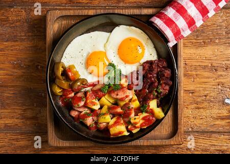Fried eggs with vegetables in pan Stock Photo