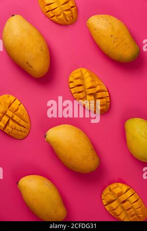 Flat lay mango fruit sliced in half cubes in pink colorful cardboard background Stock Photo