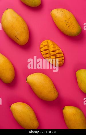 Flat lay mango fruit sliced in half cubes in pink colorful cardboard background Stock Photo