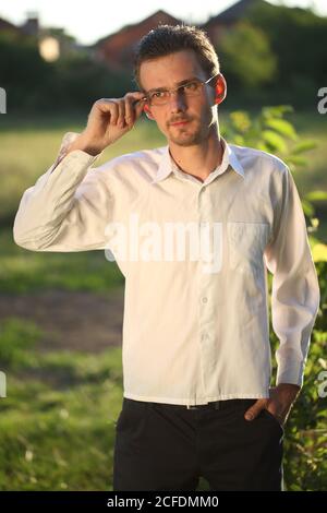 Young man in white swordsman and glasses in the park Stock Photo