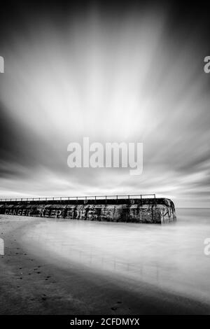 Disused stone jetty on Goleston beach. Stock Photo